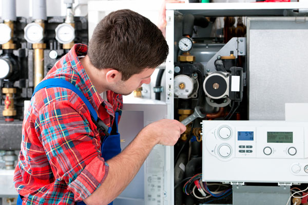 Heating technician repairing boiler controls in Inglewood