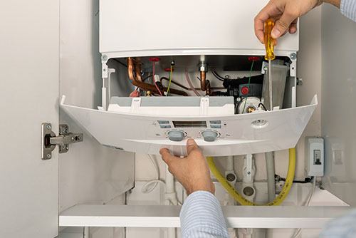 Heating technician repairing a residential boiler in Inglewood
