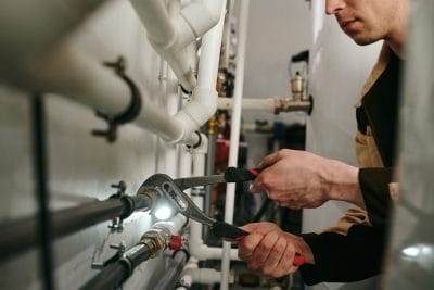 Technician inspecting commercial plumbing pipes in Inglewood