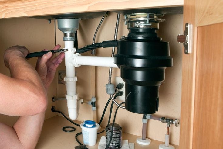Plumber repairing a garbage disposal in Inglewood