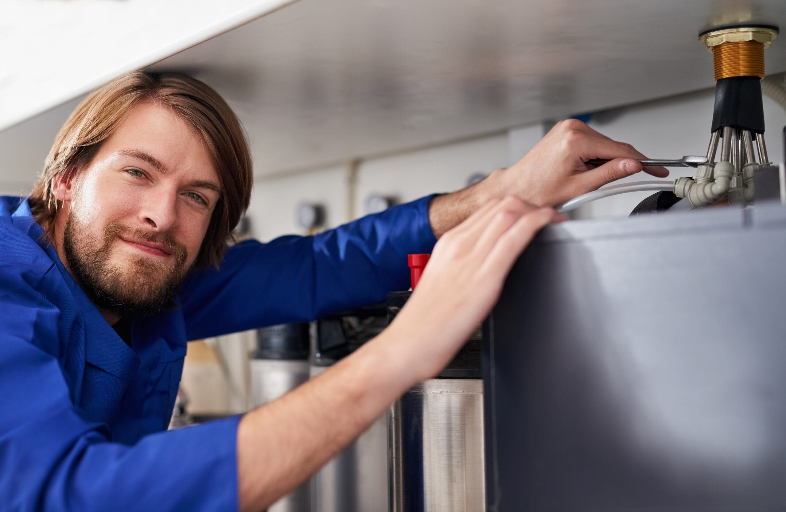Technician servicing a residential water heater tank in Inglewood